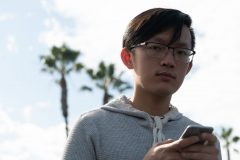 11/02/2019 – LONG BEACH, CALIF: Han looks up from his phone outside Trader Joe's on Bellflower Boulevard. Photograph by Dillon Hulse.