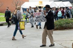 Brother Jed Smock, an evangelist from The Campus Ministry USA, brings out the "satire" on a rainy day to start a discussion with students on Tuesday, March 10, 2020. The reverse side of the sign read "Anus Awareness Day." Photograph by Dillon Hulse.